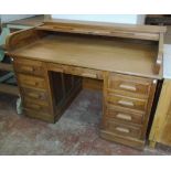 A 4' 6" early 20th Century polished oak twin pedestal roll-top architect's desk by Kenrick &