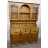 A 4' 4" waxed pine and mixed wood Ducal "Victoria" two part dresser with central open shelves and