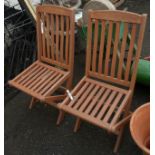 A pair of teak slatted folding chairs