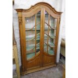 A 4' 5" modern waxed pine ornate display cabinet in the antique style with shaped dome top,