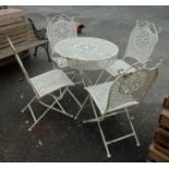 A wrought iron framed folding garden table and four chairs with inset cast iron panels