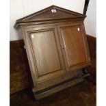 A 26" late 19th Century mahogany wall hanging cabinet with shelf enclosed by a pair of panelled