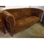 A 6' 4" Chesterfield settee upholstered in brown velour set on turned front legs and casters
