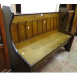 A 4' 5" 20th Century polished oak pew with panelled back and solid seat