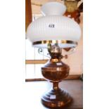 A copper table oil lamp with white glass shade
