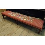 A 4' 3" Edwardian mahogany and strung long footstool with tapestry upholstery set on square