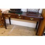 A 4' 4" 20th Century mahogany side table in the Georgian style with three frieze drawers, set on