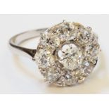 A marked "PLAT" and 18ct. circular diamond cluster ring with central raised claw set stone
