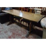 A 6' 20th Century polished oak refectory table, set on pierced standard ends with pegged stretcher