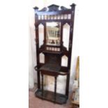An Edwardian stained wood hallstand with acanthus pediment, central bevelled mirror, shelf and glove