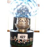 A pressed metal wall oil lamp with moulded blue glass globe