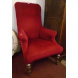 A late Victorian armchair upholstered in button back red velour, set on turned and fluted front legs