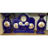 A ceramic clock garniture with printed Kaufmann style reserve panels on cobalt blue ground,