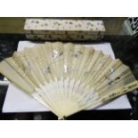 A boxed bone fan with sequin decoration on gauze