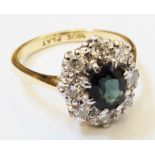 A marked 18ct. and "PLAT" ring, set with blue/green central oval sapphire within a diamond encrusted