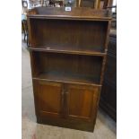 A 22" early 20th Century polished oak book cabinet with two open shelves and pair of panelled
