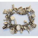 A white metal charm bracelet set with numerous charms