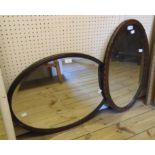 Two early 20th Century oak framed oval wall mirrors with bevelled plates