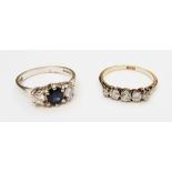 An 18ct. gold ring, set with central dark sapphire flanked by two diamonds - sold with an 18ct.