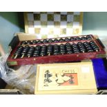 A box containing a chess set, abacus, cased scales, etc.