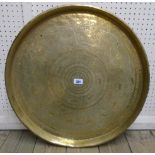 A 23" diameter Middle Eastern brass tray top table with repeat animal and floral decoration, set