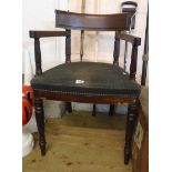 An early 19th Century mahogany framed elbow chair with curved back rail and upholstered seat, set on