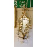 A decorative gilt metal framed twin sconce wall mirror with cut glass flower heads and drops