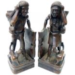 A pair of Asian hardwood bookends in the form of figures with head baskets