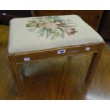 An oak framed footstool with tapestry seat, set on simple square legs