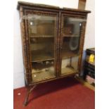 A 33½" 19th Century bamboo book cabinet with two shelves enclosed by a pair of glazed panel