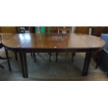 A 7' 11" mahogany D-end dining table with two end sections, set on square tapered legs with spade