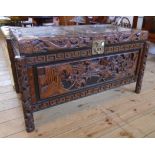 A 3' 6" Oriental carved camphorwood chest with high relief battle scene under glass to lid, the
