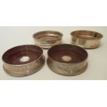 A pair of silver coasters with stained oak bases - Birmingham 1989 - sold with a pair of plated