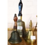 A large hand bell with turned wood handle and two smaller similar bells