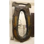 A wall mirror framed within an antique continental heavy horse collar with studded leather