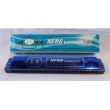 A boxed Chinese Hero harmonica in polished blue finish