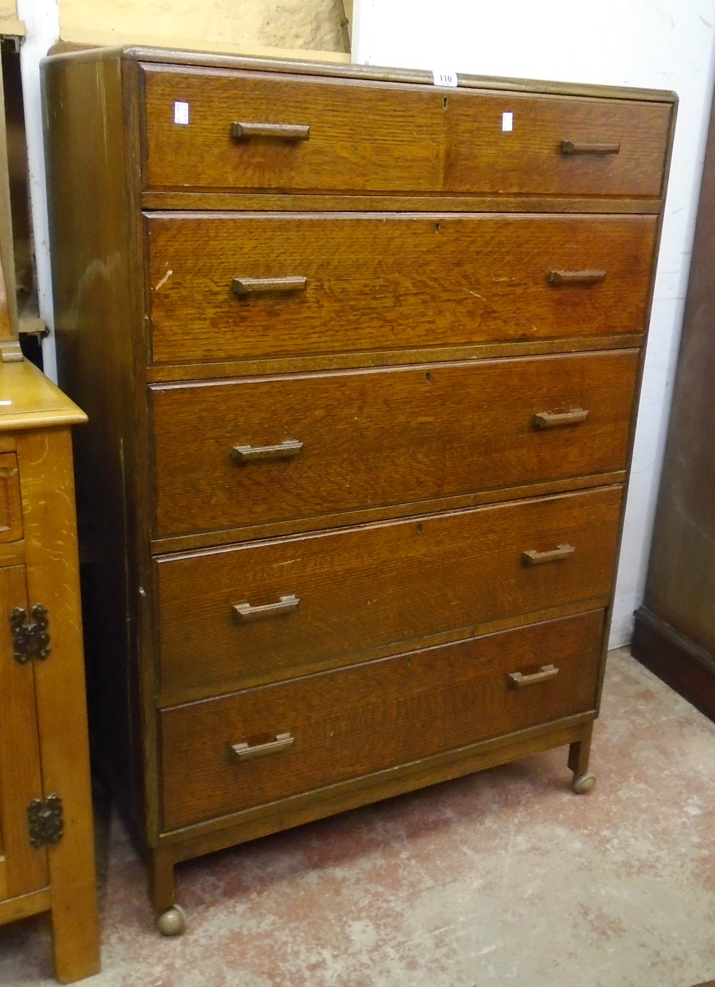 A 36" 20th Century polished oak chest of five long graduated drawers, set on raised legs with