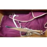 Three cutlery wraps containing a quantity of assorted silver plated cutlery including Harrods