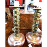A pair of early 19th Century copper and brass spiral ejector candlesticks with weighted bases -