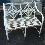 A 3' 4" painted wrought iron garden bench with scrollwork back and slatted seat