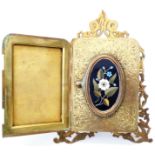 A late 19th Century brass triple fold photograph frame with pietra dura floral panel, bearing H.