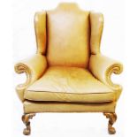 A late Victorian armchair in the Queen Anne style, upholstered in brass studded buff leather, set on