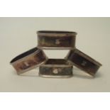 Four silver flattened oval napkin rings with engraved numbers and cast rims - Birmingham 1925