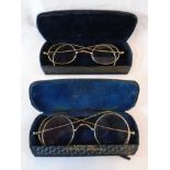 Two pairs of yellow metal framed spectacles with cases