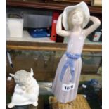 A Lladro figure of a girl holding onto her hat - sold with a Lladro cherub