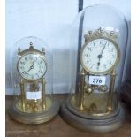 Two anniversary clocks, both under glass domes