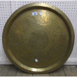A Nigerian 23" diameter brass tray top table, signed Aikin (sic) Amadu Kano, set on a typical