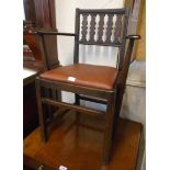 A vintage Ercol dark stained wood framed elbow chair with shaped lath back and upholstered drop-in