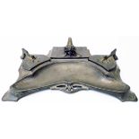 An Art Nouveau pewter desk stand with central blotter and flanking inkwells