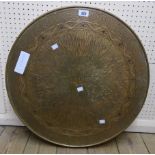A 23½" diameter brass clad topped table with decorative starburst design, set on a stained wood